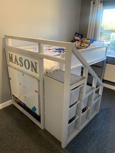 a child's room with a loft bed and storage bins on the bottom floor