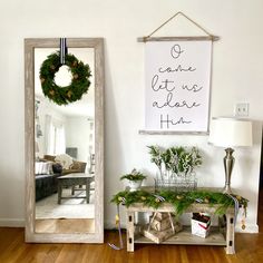 a mirror sitting on top of a wooden floor next to a shelf filled with plants