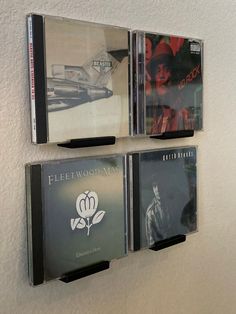 three cd's hanging on the wall in front of each other