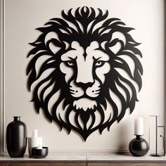 a metal lion head mounted to the side of a wall next to two black vases