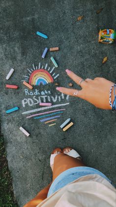 a person pointing at chalk writing on the ground