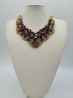 Each piece of our statement necklaces is handmade and one of a kind made in Italy. Our creations is made of high quality materials such as crystals and rhinestones. Each embroidered material is carefully hand sewn. Very glamorous and stylish. Perfect gift to someone you like. Materials Strass stone and Rhinestone in Burgungy and Montana color in different dimension.  Black satin fabric backing. Aluminium chain with lobster closure. Measurements Weight approximate 200 grams. Chain lenght 25 cm - 9.84 in Circumference approximate 63 cm - 24.80 in Feel free to contact us if you have any question. Thank you so much for looking at our shop and our articles each of them, single piece. Luxury Handmade Multicolor Necklaces, Luxury Handmade Multicolor Necklace, Handmade Pendant Necklace For Party, Unique Necklaces With Jewels For Parties, Unique Jeweled Necklace For Party, Handmade Formal Choker Necklace, Formal Handmade Choker Necklace, Handmade Party Pendant Crystal Necklace, Costume Jewelry Jeweled Choker Necklace