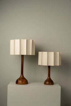 two lamps sitting on top of a white block