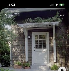 the front door of a house with two potted plants