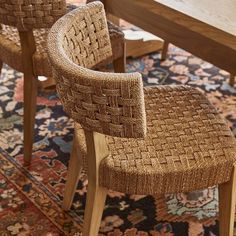 two woven chairs sitting on top of a rug next to a wooden table and bench