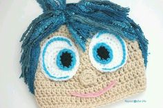 a crocheted hat with blue eyes and hair