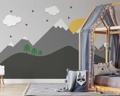 a child's bedroom with mountains and trees painted on the wall, along with a canopy bed