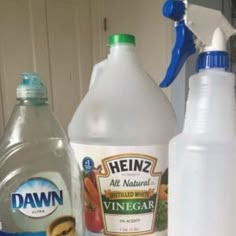 two bottles of vinegar, one with a blue cap and the other white