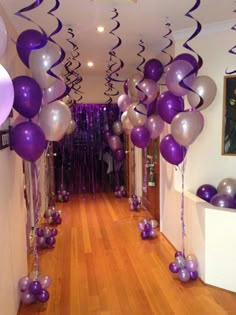 purple and silver balloons are hanging down the hallway