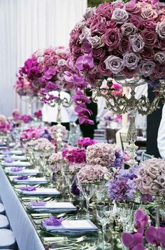 the table is set with purple and pink flowers