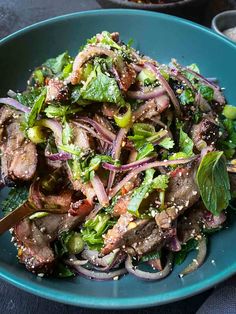 a blue bowl filled with meat and veggies