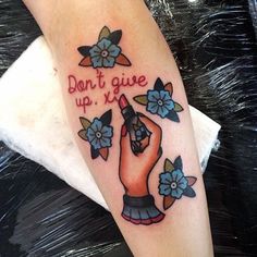 a person with a tattoo on their arm that says don't give up it