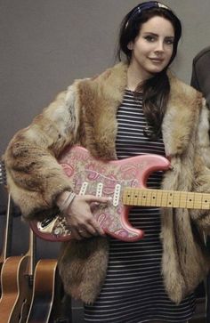 two people standing next to each other holding guitars