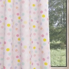 a window with polka dot curtains in front of it