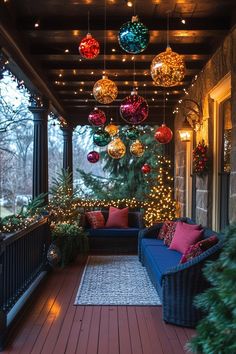 a porch decorated for christmas with ornaments and lights hanging from it's ceiling above the couch