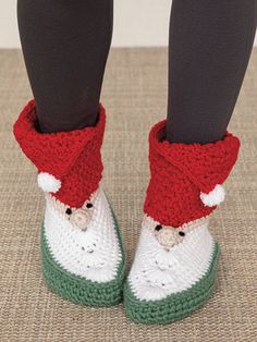 the legs and feet of a person wearing slippers with santa clause on them,