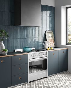 a kitchen with blue and white tiles on the walls, counter tops, and drawers