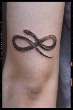 a black and white tattoo design on the side of a woman's leg, with an infinite symbol