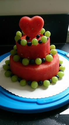 a watermelon cake with grapes and a heart on top