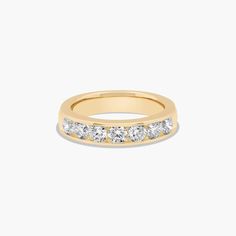 a yellow gold wedding ring with five diamonds on the outside and inside, set against a white background