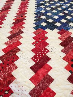 a red, white and blue quilt is laying on the floor with it's edge stitched together