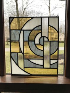 a close up of a stained glass window with trees in the backgroung