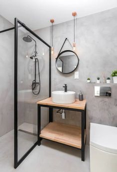 a bathroom with a sink, mirror and shower stall in the corner next to a toilet