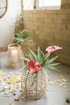 some flowers are in a basket on the floor next to other plants and decor items