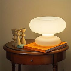 a lamp sitting on top of a table next to a book