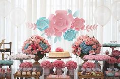 a table topped with lots of cakes and flowers