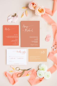 the wedding stationery is laid out on top of pink and orange ribbons, scissors, and flowers