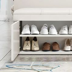 several pairs of shoes are lined up on a white bench in front of a wall