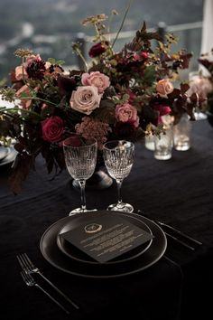 the table is set with flowers and wine glasses