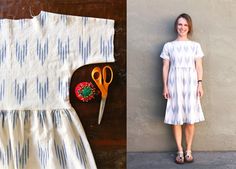 a woman standing in front of a wall next to a dress and pair of scissors