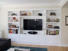 a living room filled with furniture and a flat screen tv on top of a wall