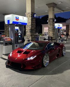 a red sports car parked in front of a gas station