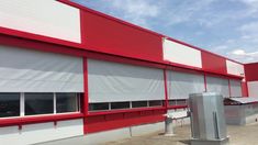 an industrial building with red and white awnings