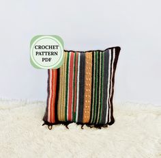 a colorful striped pillow sitting on top of a white fluffy rug with the text crochet pattern pdf above it