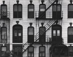 an old building with many windows and fire escapes