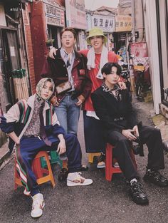 group of young men sitting on chairs in the street