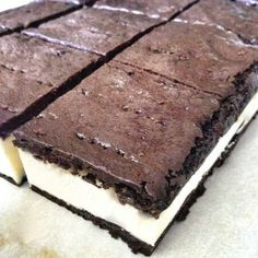 there is a piece of chocolate cake on the table with white frosting and icing