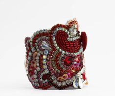 This beautiful red crystal cuff is made from tones of rhinestones, swarovski crystal and vintage treasure; in shades of reds and pinks with clear crystals.Just be gorgeous on your wedding day! This Statement piece will complete your bridal ensemble or add sparkle to any other special occasion.* Cuff Features*Completely unique Just over 2 1/2'' wide at widest pointLined in soft leatherClasp closure or ribbon bow tie in red Fits most wrist or I can make fit you specially just give me your wrist si Red Crystal Bracelet For Wedding, Luxury Red Rhinestone Jewelry, Red Adjustable Cuff Bracelet For Wedding, Adjustable Red Cuff Bracelet For Wedding, Red Cuff Bracelet For Wedding, Red Rhinestone Bracelets For Party, Red Crystal Bracelets With Rhinestones, Red Embellished Wedding Jewelry, Red Embellished Party Jewelry