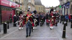 a group of men in kilts marching down the street