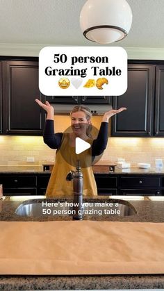 a woman standing in front of a kitchen counter holding up a sign that says 50 person grating table