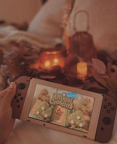 someone is playing an animal crossing game on their nintendo wii console in front of some candles