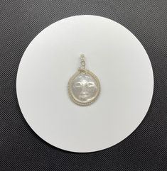 Carved Mother of Pearl Face Pendant in Wire Wrapped Argentium Silver with Rainbow Moonstone Accent. Approximately 2" long and 1 3/8" wide. Argentium silver contains a greater amount of pure silver (935 which contains 93.5% pure silver with the remainder being made up of other alloys, such as a small amount of germanium). This makes it more tarnish resistant than Sterling (.925) Silver. Moon Shaped Silver Jewelry For Anniversary, Silver Oval Celestial Necklace, Silver Celestial Oval Jewelry, Silver Wire Wrapped Round Pendant Jewelry, Silver Wire Wrapped Jewelry With Round Pendant, Silver Celestial Pendant Jewelry, Celestial Silver Oval Necklace, Spiritual Silver Moonstone Jewelry, Celestial Nickel-free Silver Jewelry