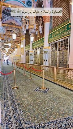 the inside of an ornate building with gold and blue decorations on the walls, chandeliers and carpeted floors