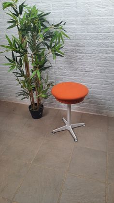 an orange table sitting next to a potted plant