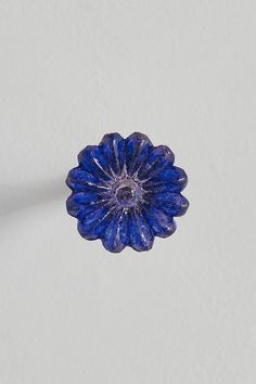 a blue flower on a white surface with a shadow from the center and back side