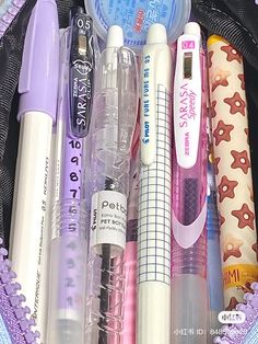 various pens and pencils in a purple bag